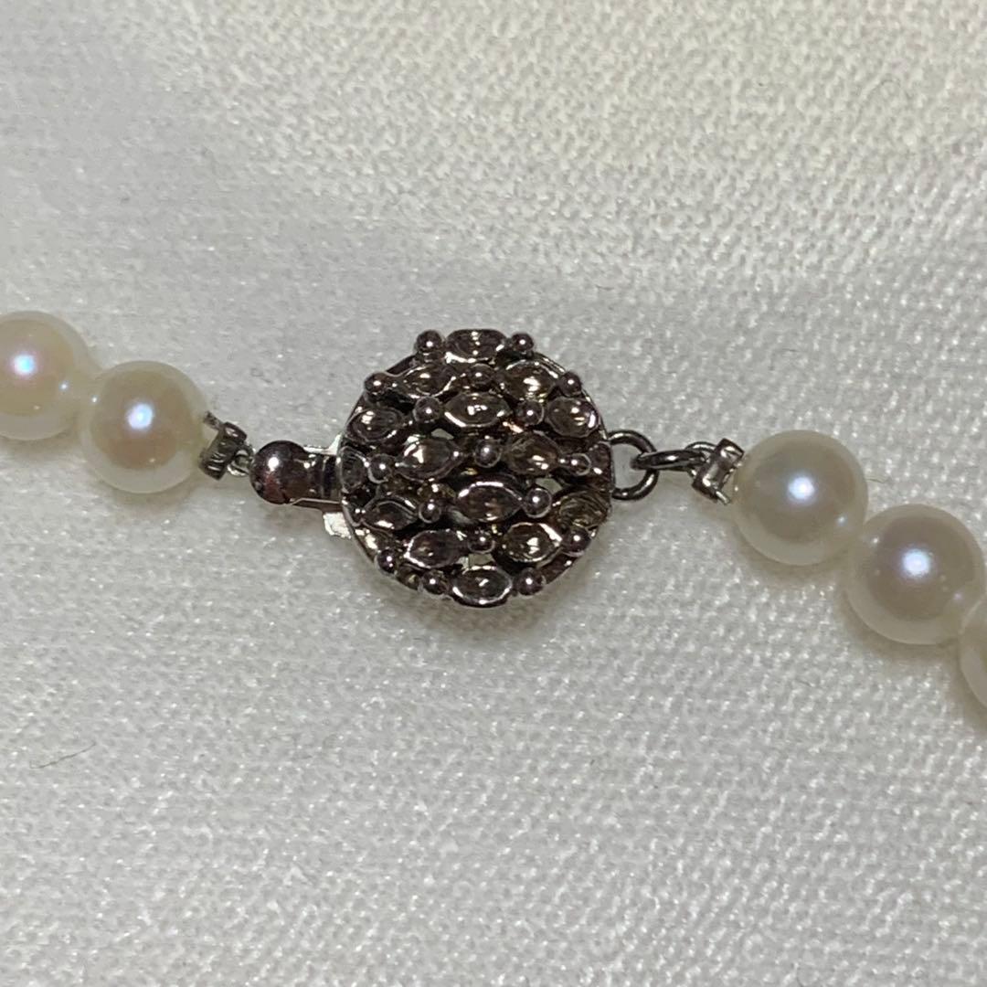 Akoya pearl necklace with 43 cm length and 6.1 to 5.5 mm round pearls on white background