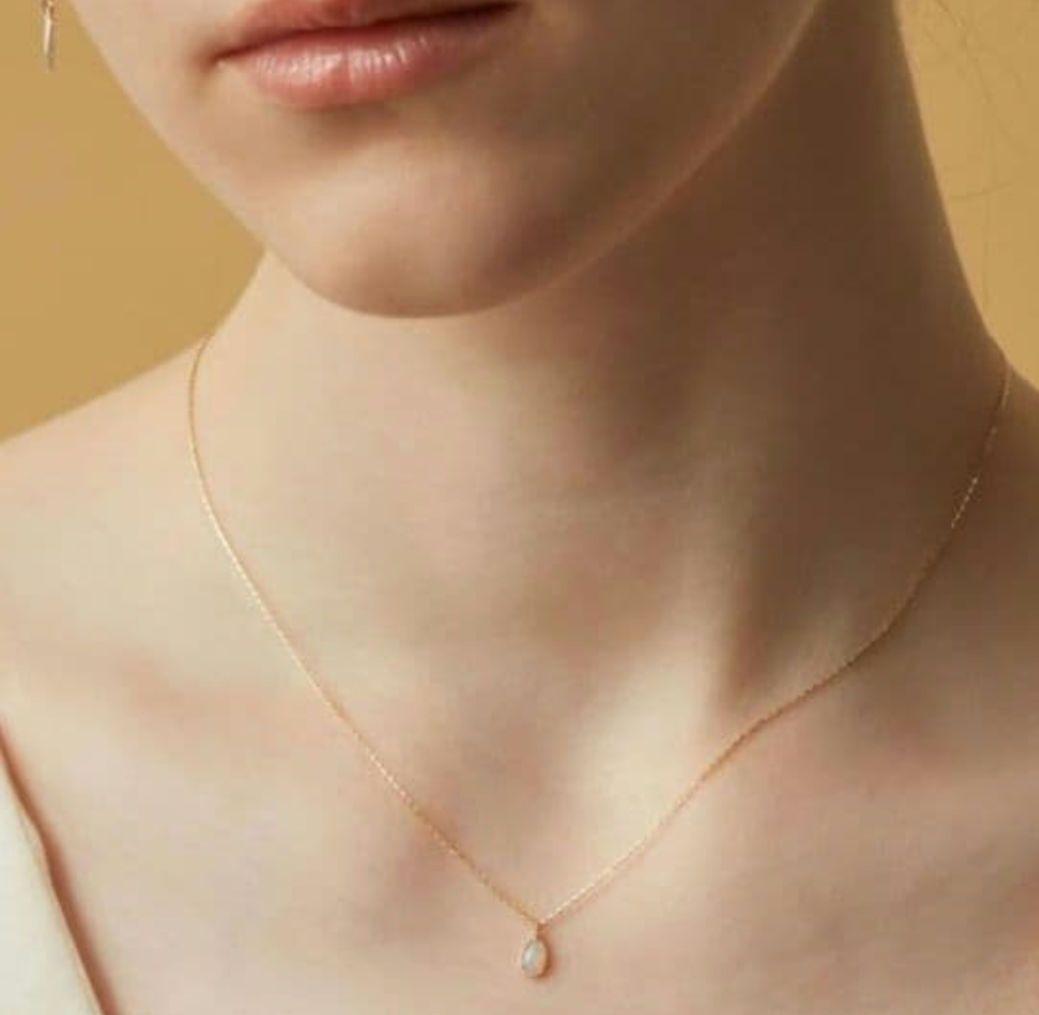 Current Model Agate K10 necklace with opal pendant measuring 0.6 by 0.4 cm on 40 cm gold chain