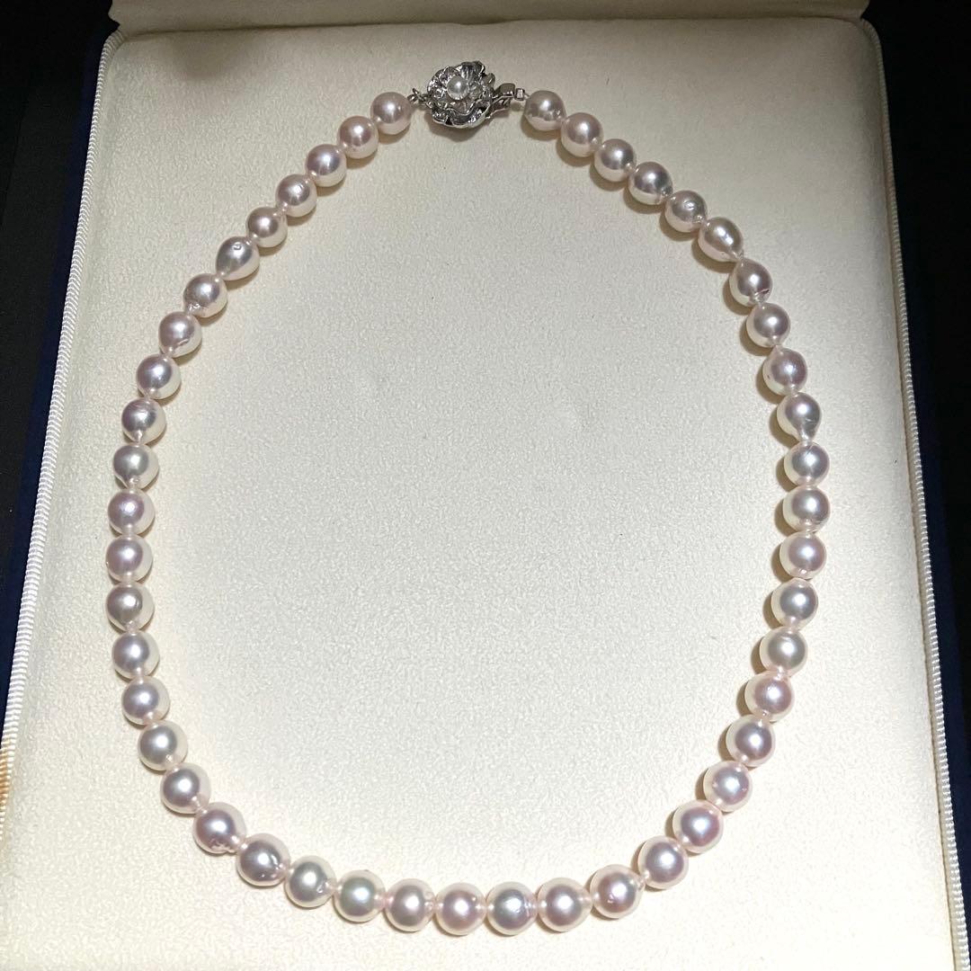 Akoya pearl necklace with white to light pink 8.0mm pearls and silver flower motif clasp on white background