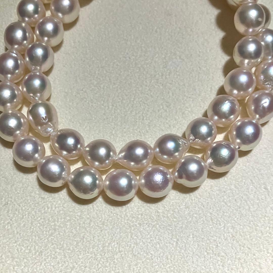 Akoya pearl necklace with white to light pink 8.0mm pearls and silver flower motif clasp on white background