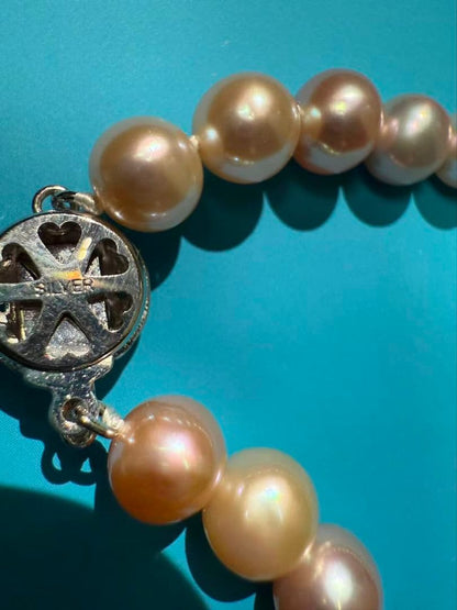 Close-up of a single lustrous Akoya pearl on a white background