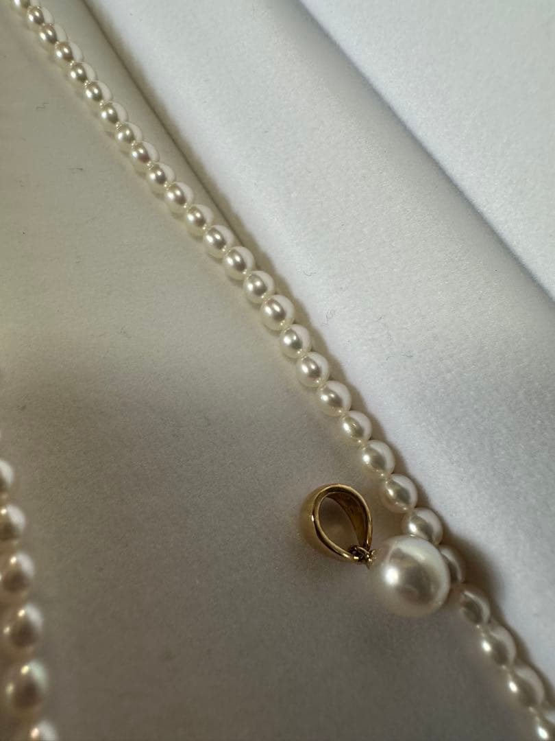 Tasaki K18 gold pearl necklace with small pearls and single larger pearl at end, 42cm length