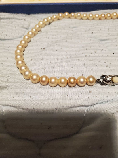 MIKIMOTO pearl necklace featuring round pearls and a pearl decorated clasp