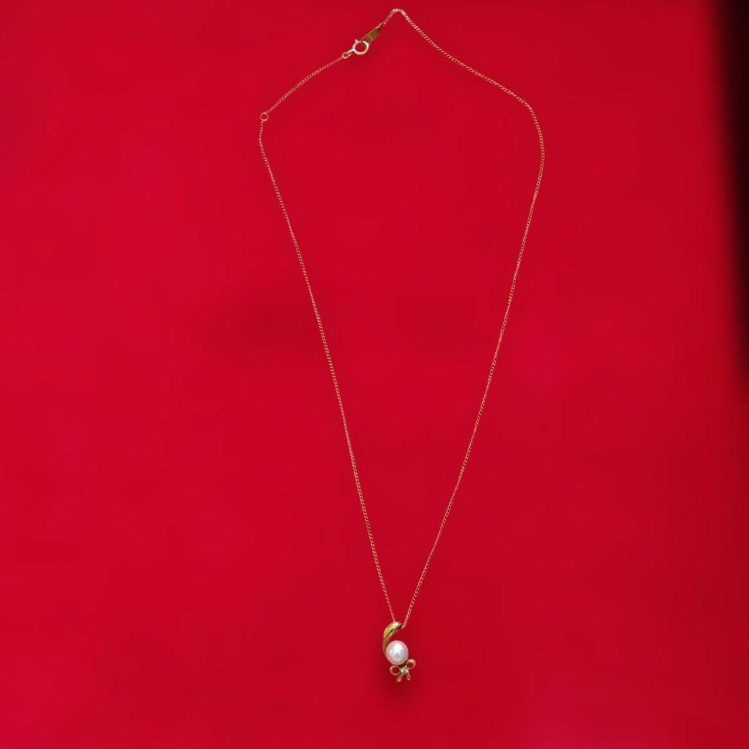 K18 yellow gold necklace with pearl and diamond decorations in a ribbon motif weighing 4 grams