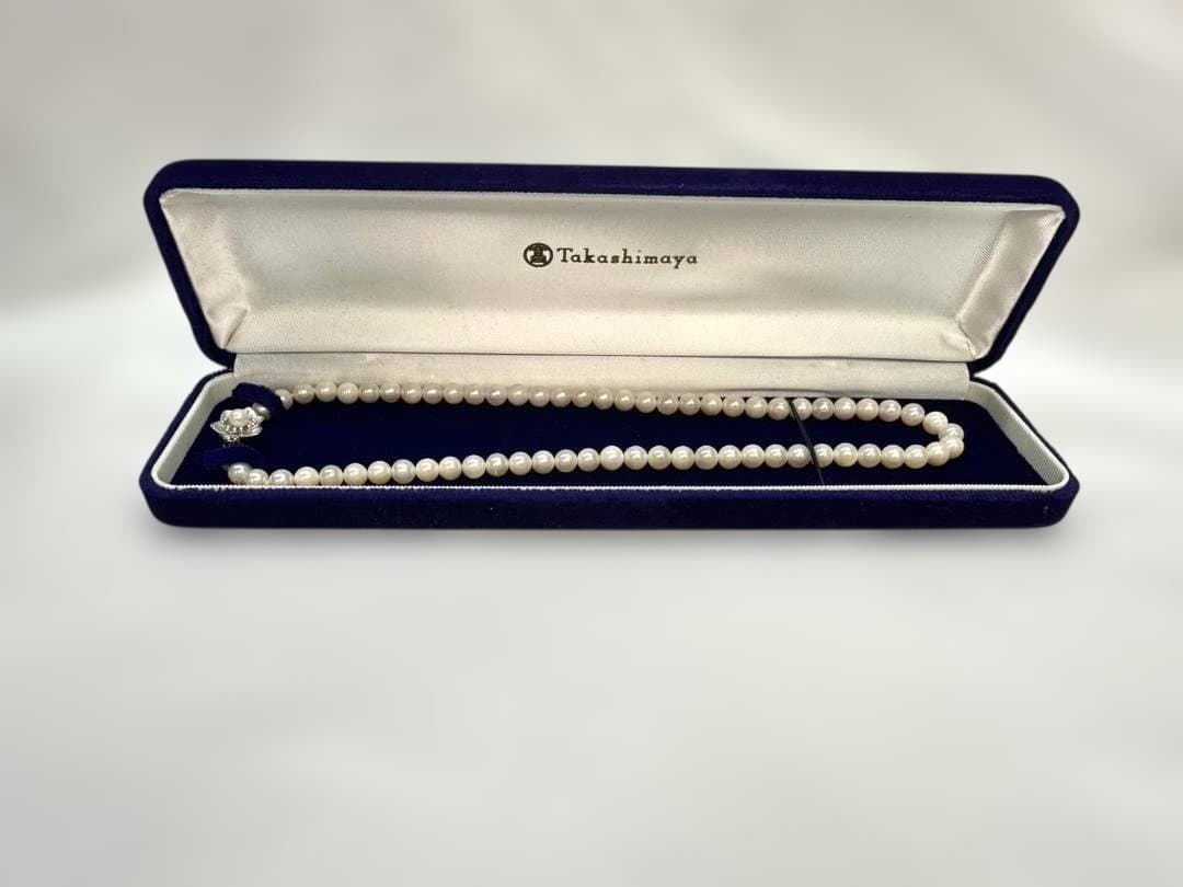 Akoya pearl necklace with 6.0mm pearls and silver clasp, displayed with stamped case