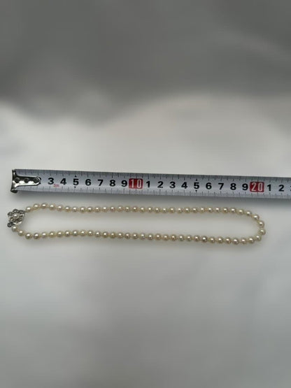 Akoya pearl necklace with 6.0mm pearls and silver clasp, displayed with stamped case