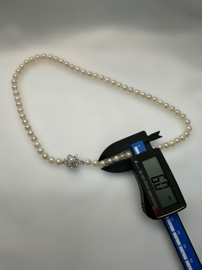 Akoya pearl necklace with 6.0mm pearls and silver clasp, displayed with stamped case