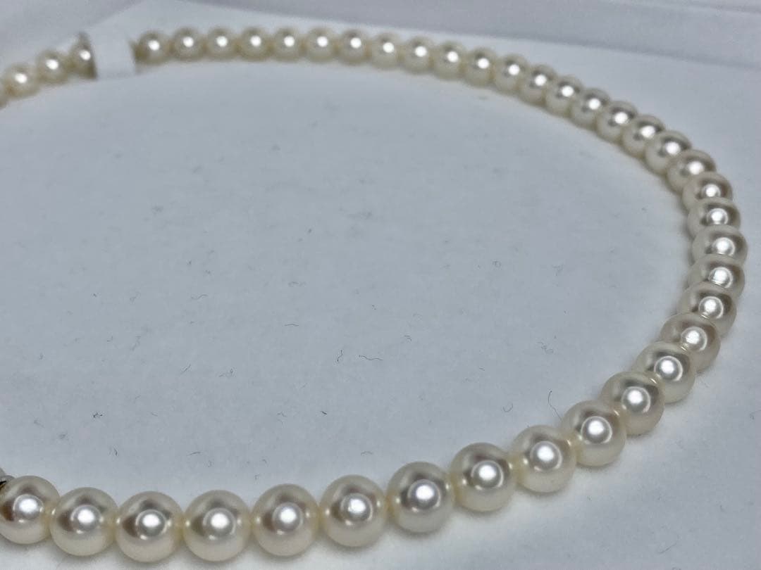 MIKIMOTO K14 Akoya pearl necklace with 6.5-7mm pearls, M charm, and K14WG mark on white background