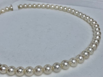 MIKIMOTO K14 Akoya pearl necklace with 6.5-7mm pearls, M charm, and K14WG mark on white background