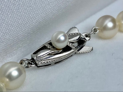 MIKIMOTO K14 Akoya pearl necklace with 6.5-7mm pearls, M charm, and K14WG mark on white background