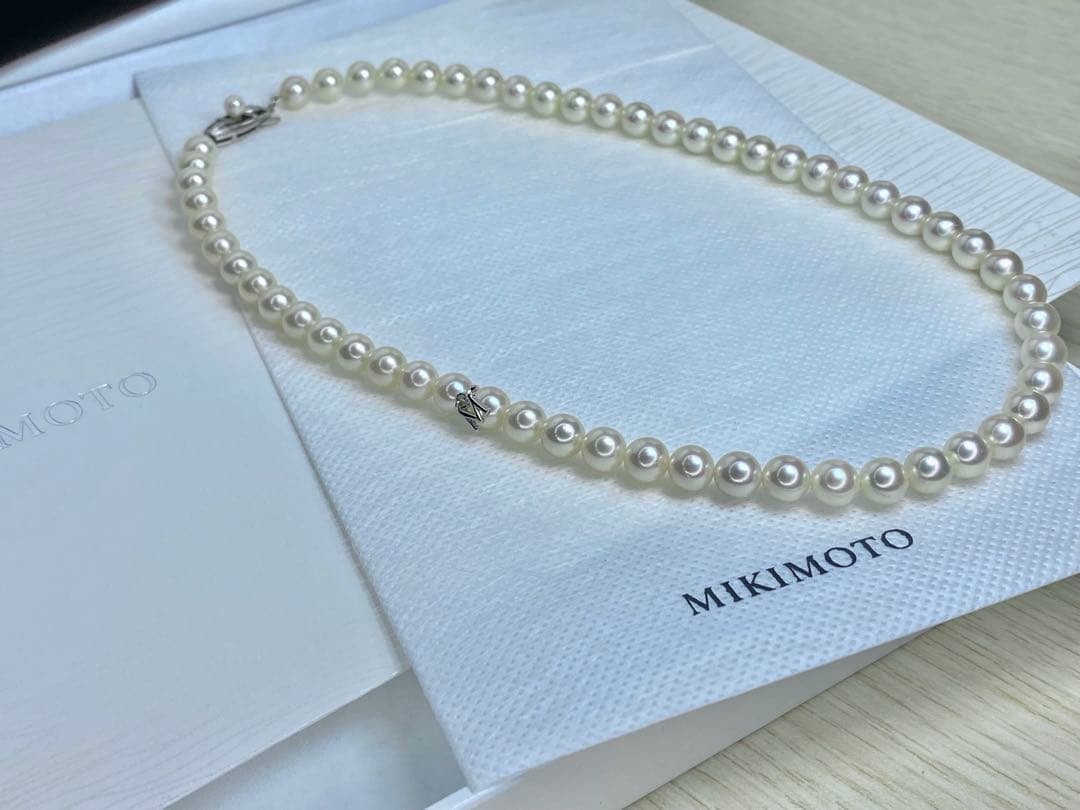 MIKIMOTO K14 Akoya pearl necklace with 6.5-7mm pearls, M charm, and K14WG mark on white background