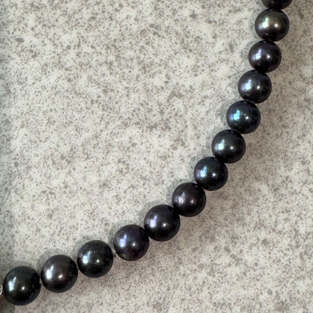 Honma Pearl genuine black Akoya pearl necklace with 7.4mm pearls and silver clasp on a white background