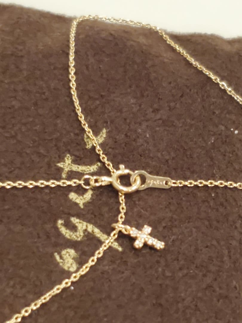 Agete gold necklace with a detailed cross motif pendant on a fine gold chain