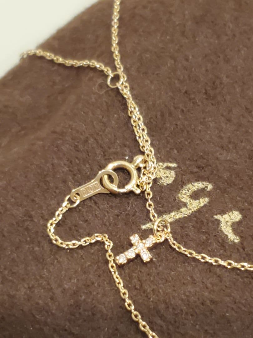 Agete gold necklace with a detailed cross motif pendant on a fine gold chain