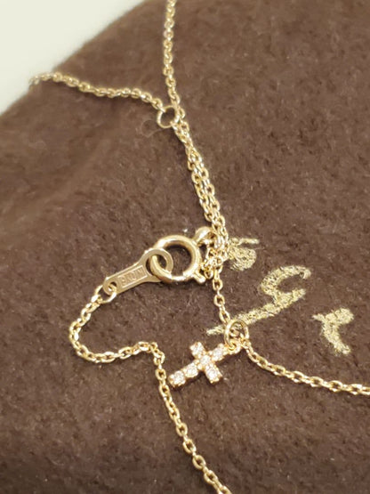 Agete gold necklace with a detailed cross motif pendant on a fine gold chain