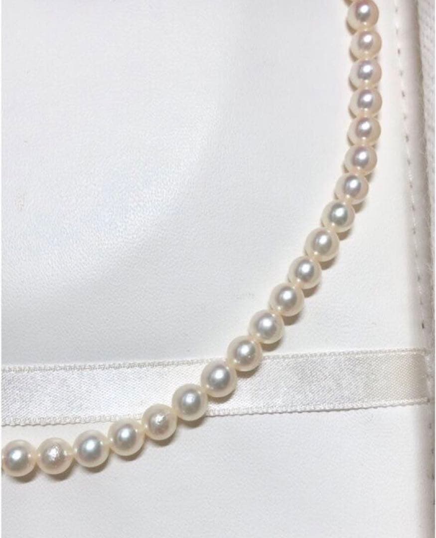 Akoya pearl necklace with round white pearls 5.5-6.0mm and silver clasp on a white background