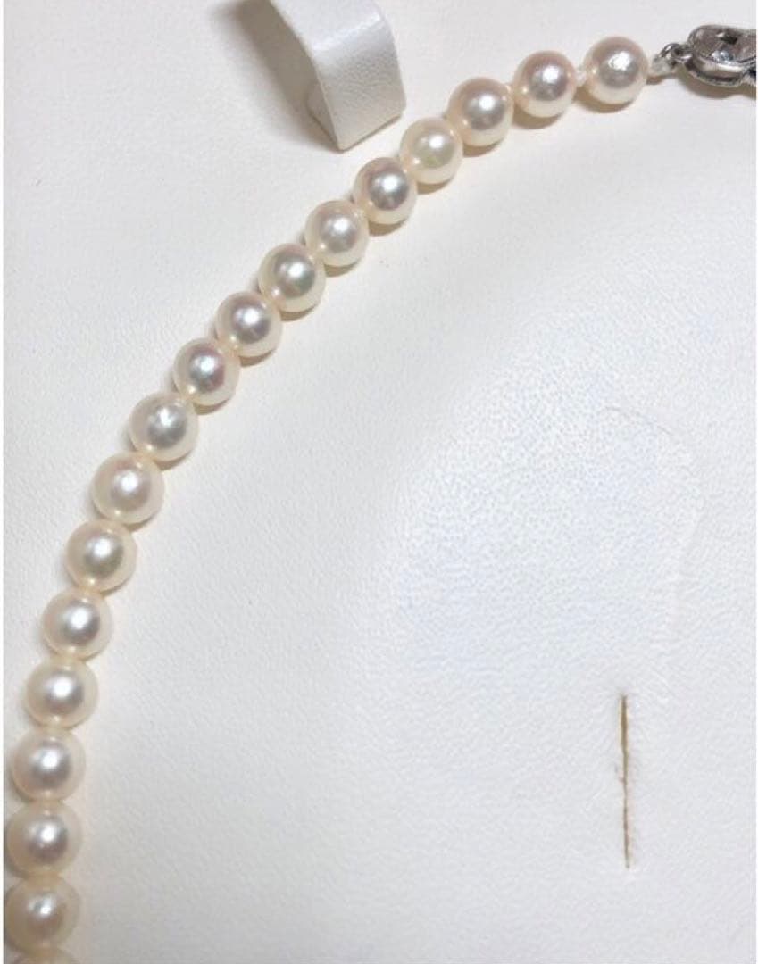 Akoya pearl necklace with round white pearls 5.5-6.0mm and silver clasp on a white background