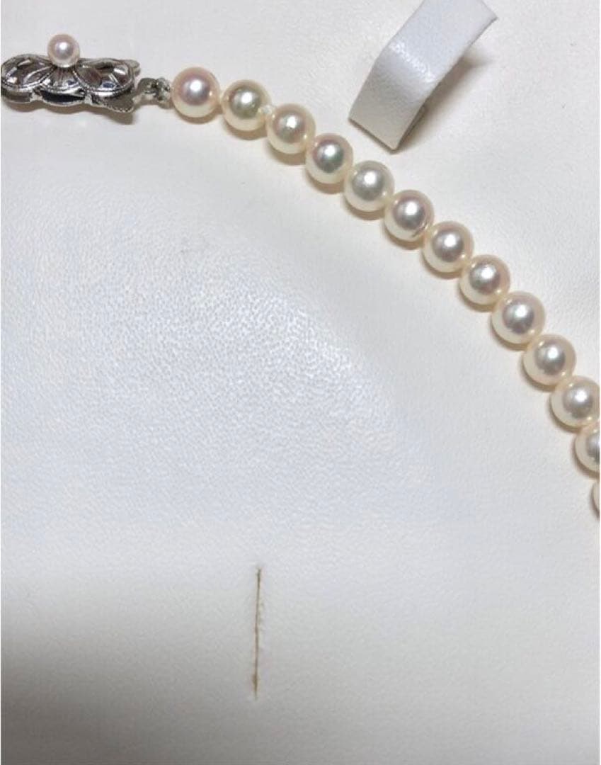 Akoya pearl necklace with round white pearls 5.5-6.0mm and silver clasp on a white background