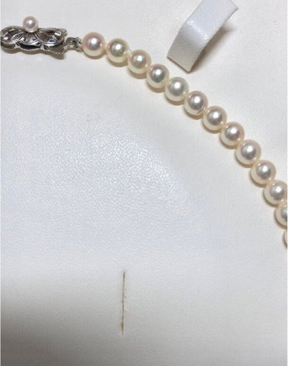 Akoya pearl necklace with round white pearls 5.5-6.0mm and silver clasp on a white background