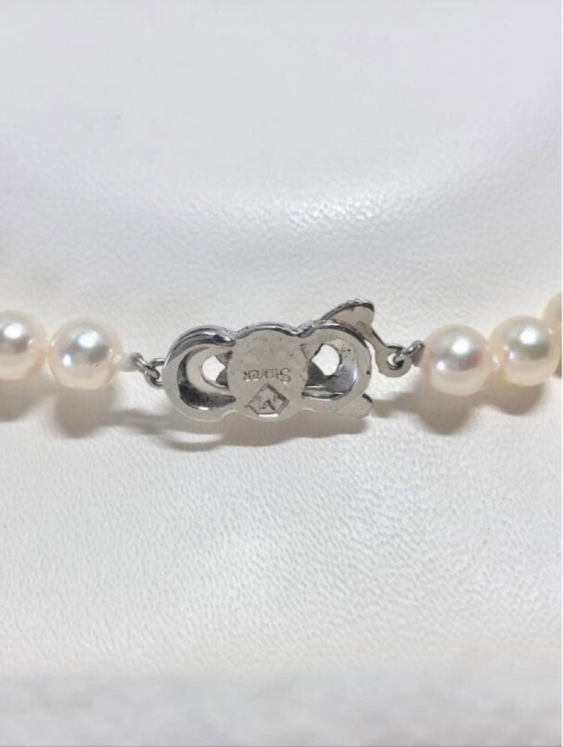 Akoya pearl necklace with round white pearls 5.5-6.0mm and silver clasp on a white background