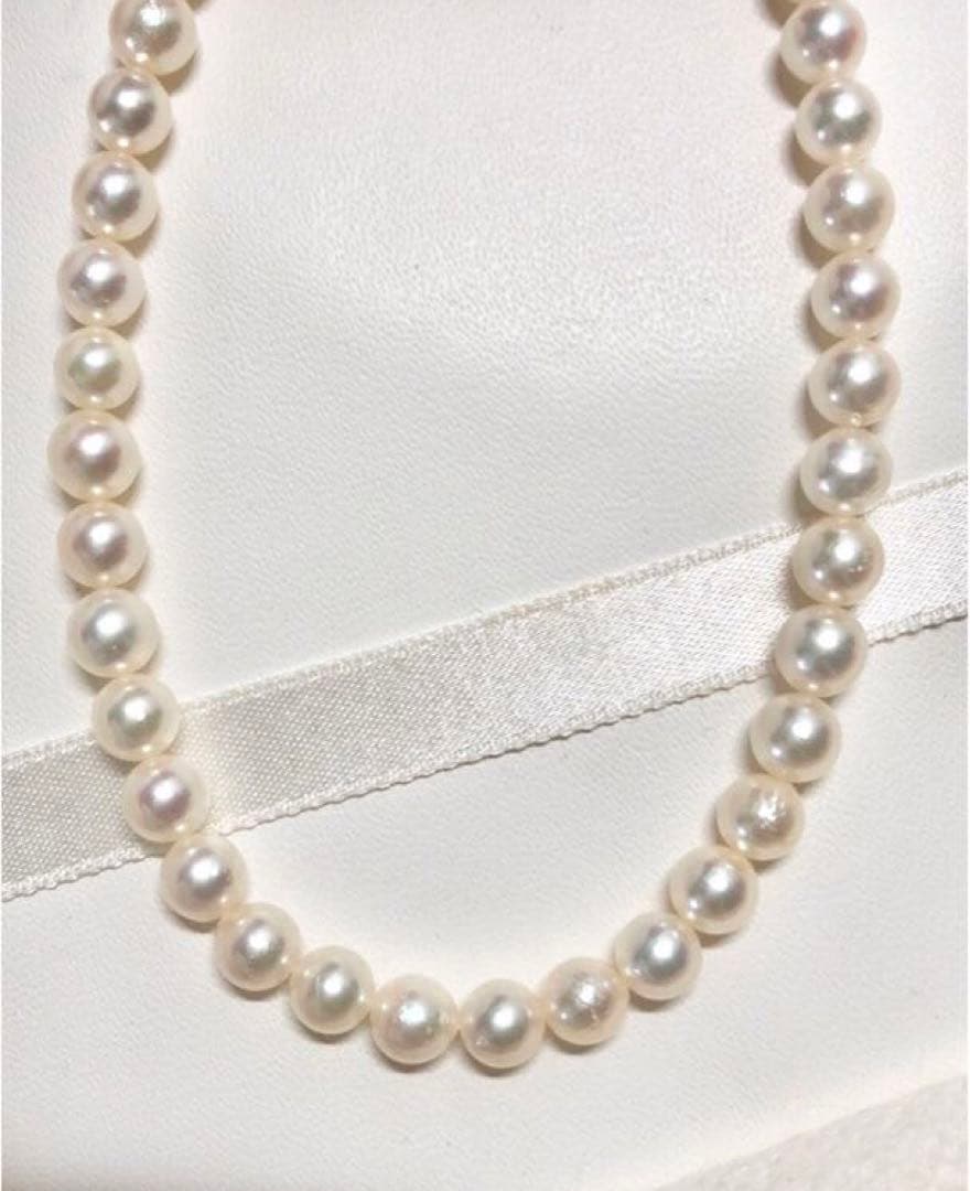 Akoya pearl necklace with round white pearls 5.5-6.0mm and silver clasp on a white background
