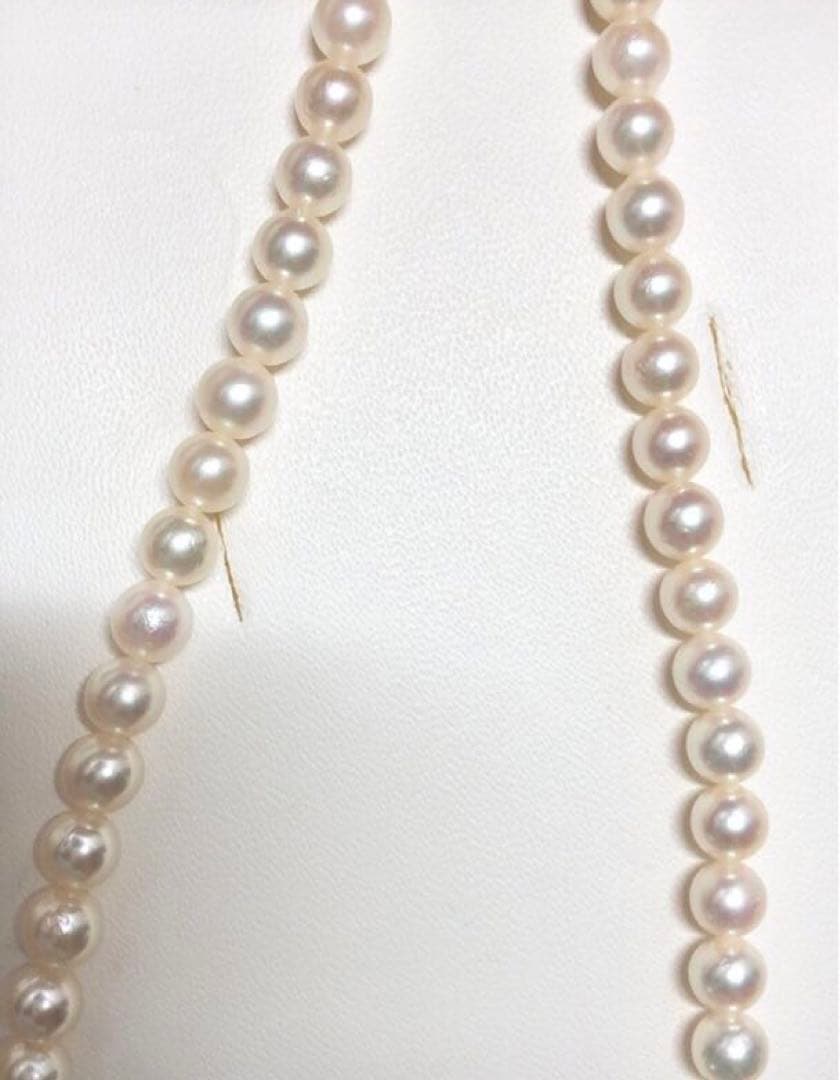 Akoya pearl necklace with round white pearls 5.5-6.0mm and silver clasp on a white background
