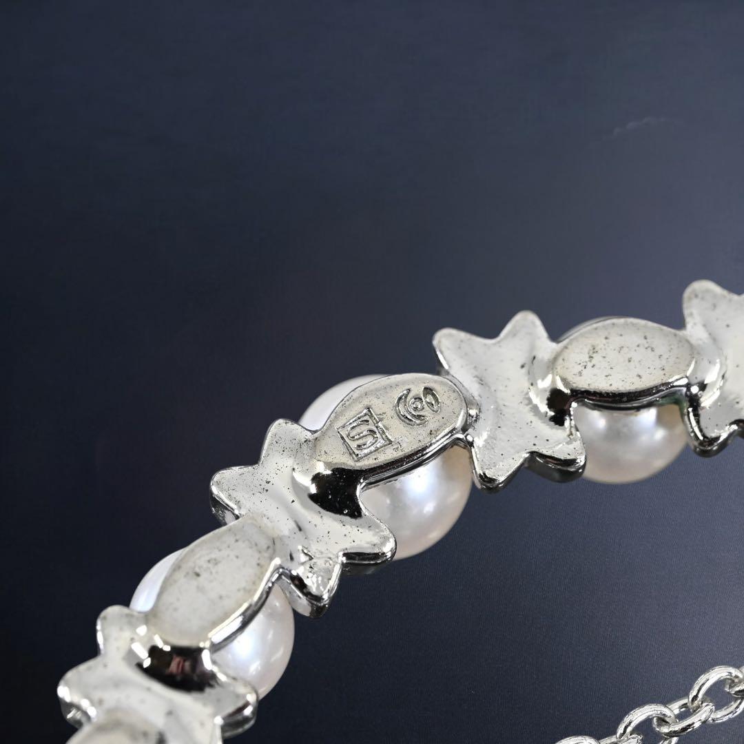 Tasaki Akoya pearl necklace pendant with round genuine pearls and silver clasp on a white background