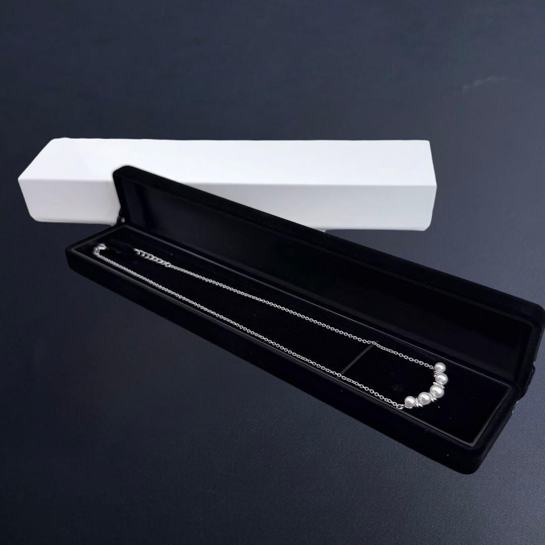Tasaki Akoya pearl necklace pendant with round genuine pearls and silver clasp on a white background