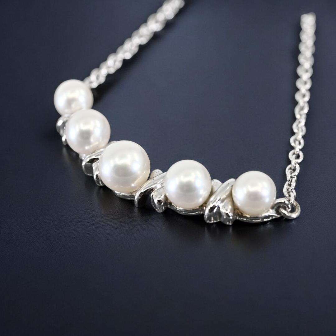 Tasaki Akoya pearl necklace pendant with round genuine pearls and silver clasp on a white background