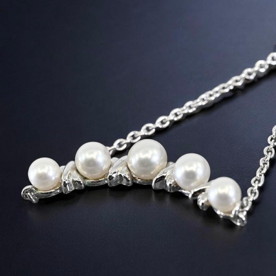 Tasaki Akoya pearl necklace pendant with round genuine pearls and silver clasp on a white background