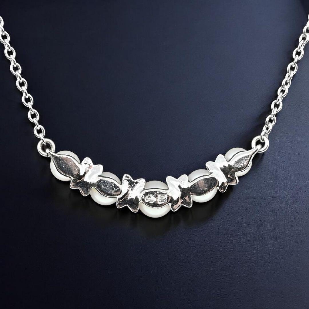 Tasaki Akoya pearl necklace pendant with round genuine pearls and silver clasp on a white background