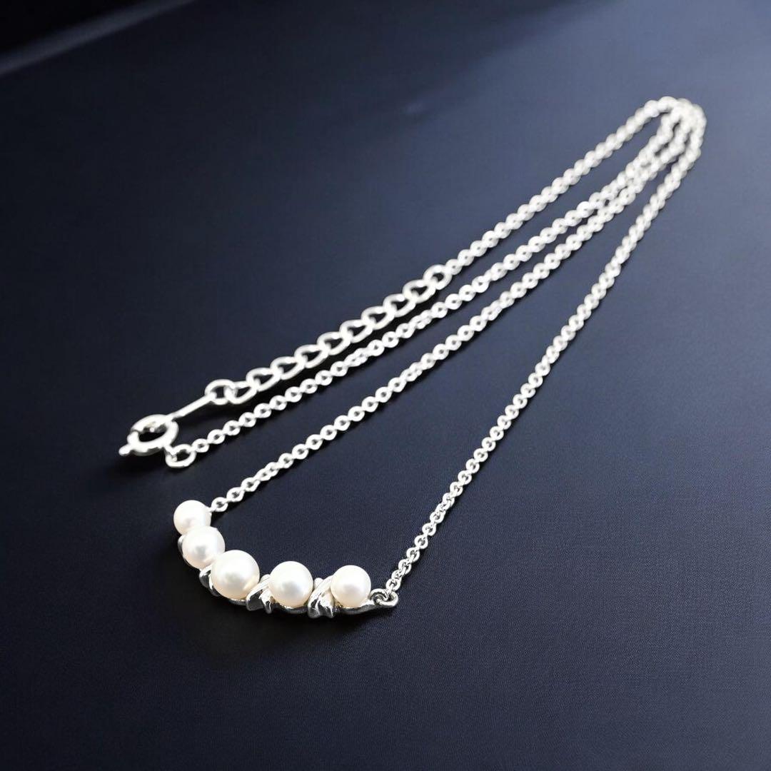 Tasaki Akoya pearl necklace pendant with round genuine pearls and silver clasp on a white background