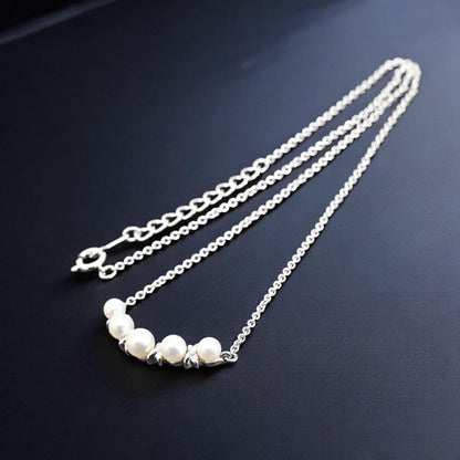 Tasaki Akoya pearl necklace pendant with round genuine pearls and silver clasp on a white background