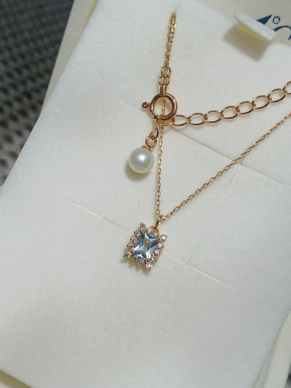 Moon Label necklace in 10K yellow gold featuring aquamarine, 0.07ct diamond, and 4mm Akoya pearl on a 43cm chain
