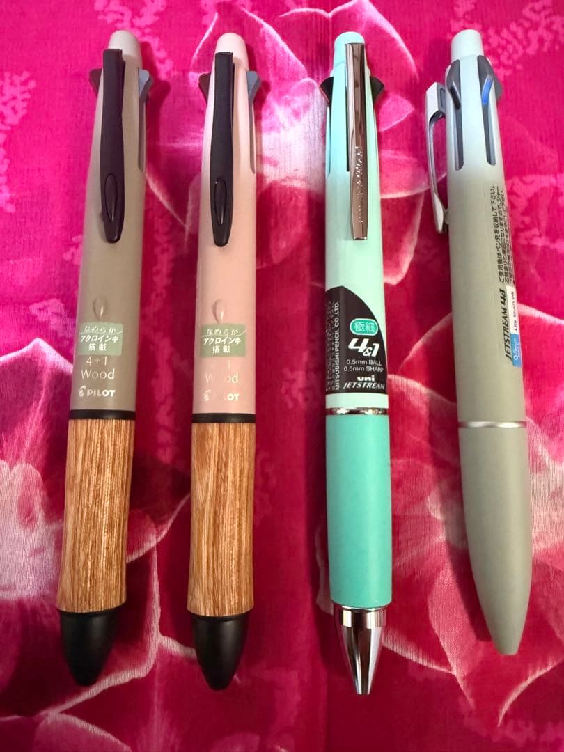 Set of four multi-color ballpoint pens, some featuring mechanical pencil function