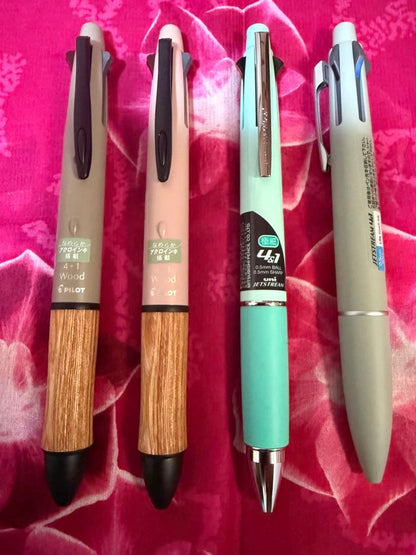 Set of four multi-color ballpoint pens, some featuring mechanical pencil function
