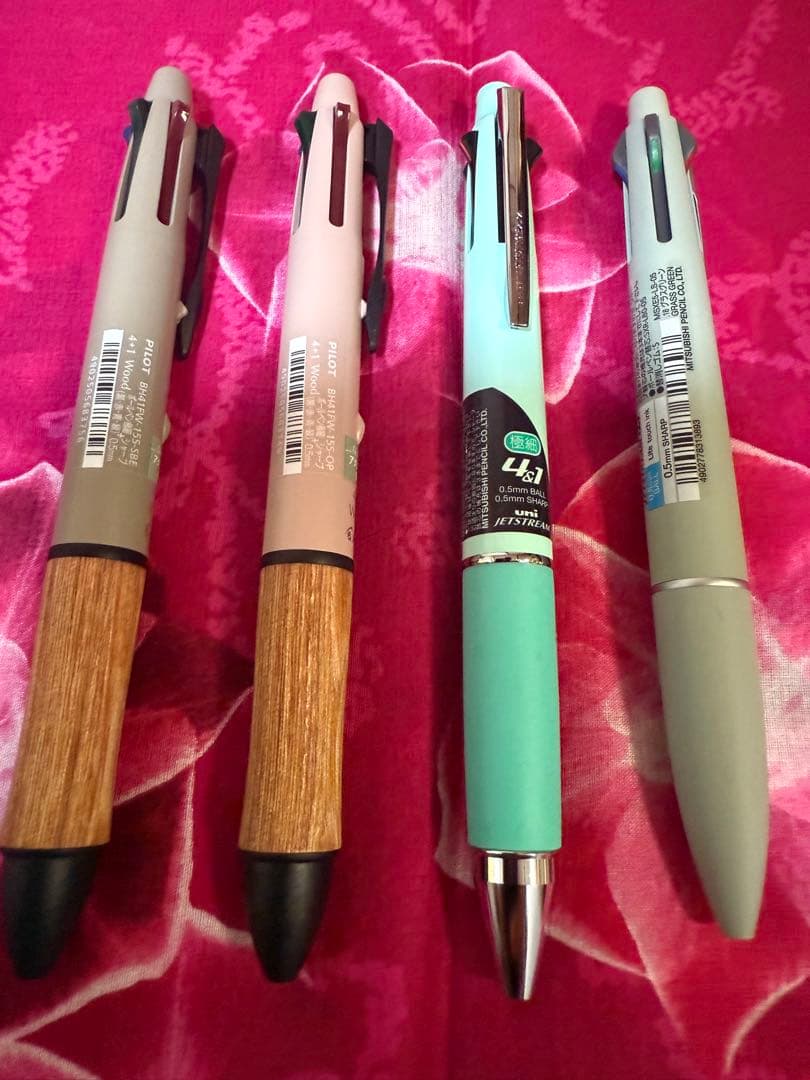 Set of four multi-color ballpoint pens, some featuring mechanical pencil function