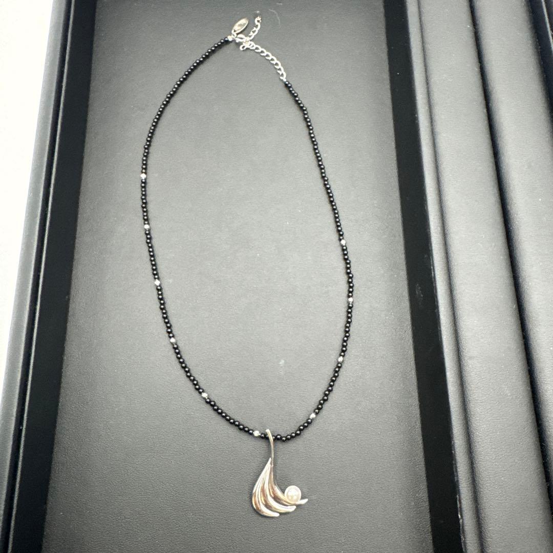Mikimoto M Mark genuine pearl pendant with thin black coral silver bead necklace on white background