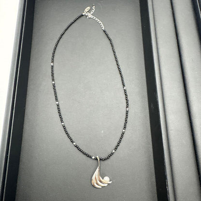Mikimoto M Mark genuine pearl pendant with thin black coral silver bead necklace on white background