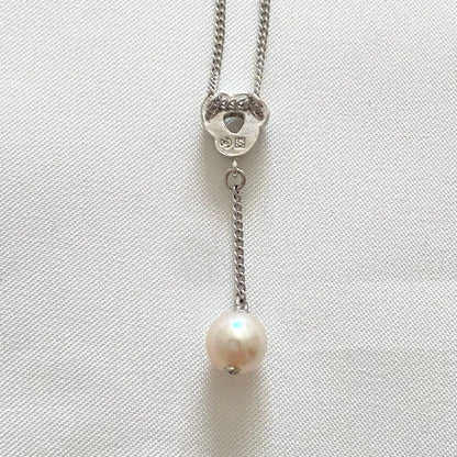 Silver Tasaki x Noevnir single pearl necklace with simple design on a white background