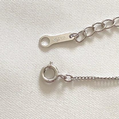 Silver Tasaki x Noevnir single pearl necklace with simple design on a white background