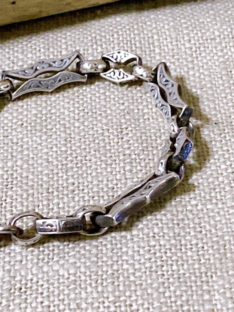 Agete Silver 925 bracelet featuring a cross motif and a pendant top on a white background