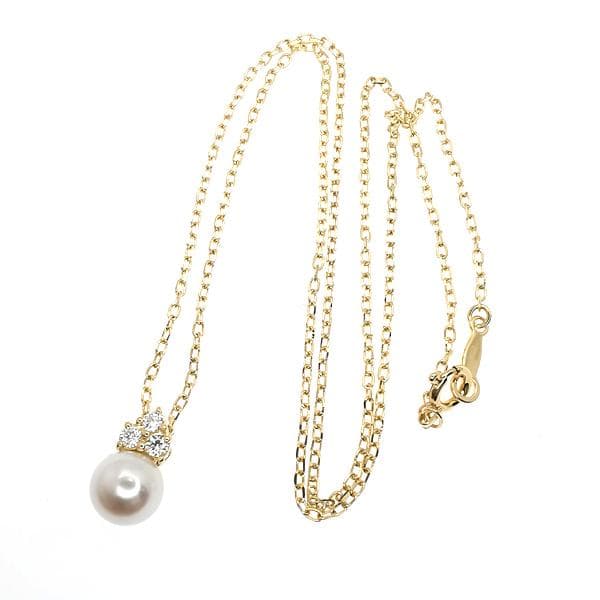 Law ring in K18 yellow gold featuring a 6.7mm pearl and diamond side stones, size height 11.3mm