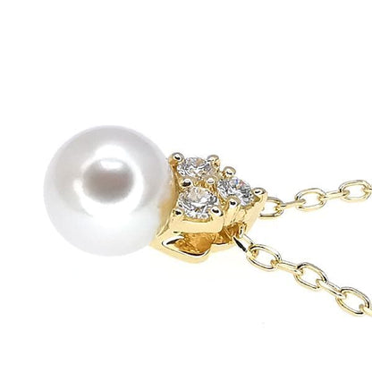 Law ring in K18 yellow gold featuring a 6.7mm pearl and diamond side stones, size height 11.3mm