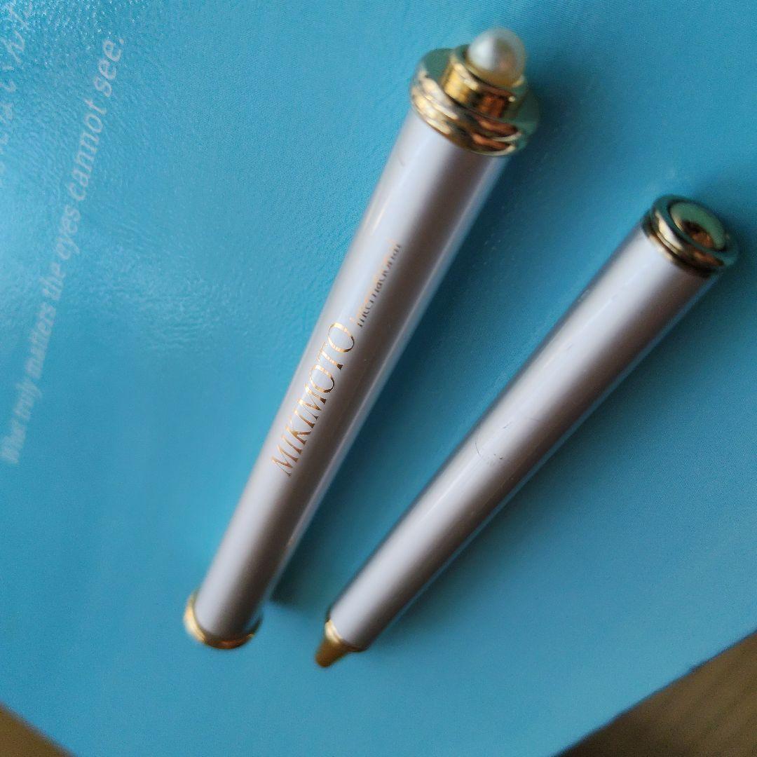 Mikimoto pendant head with decorative pearls, non-working watch, and ballpoint pen set on white background