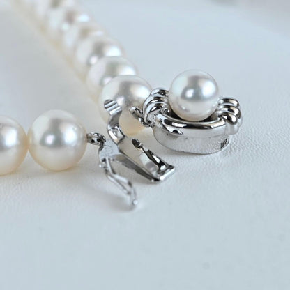 Hanadama Akoya pearl necklace with round 8-8.5mm pearls and silver fastener on a white background