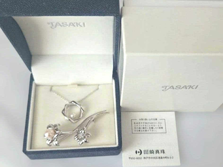TASAKI pearl necklace with 6mm pearls and silver flower motif brooch set on white background