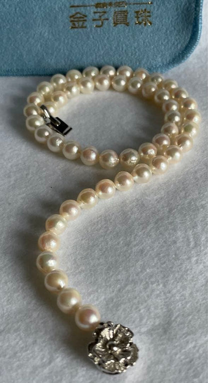 Natural 8mm Akoya pearl necklace with baroque pearls and silver clasp on a white background