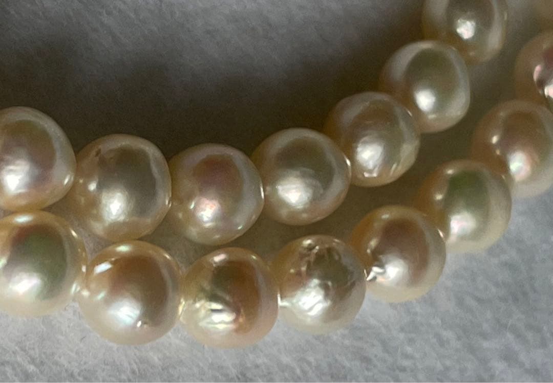 Natural 8mm Akoya pearl necklace with baroque pearls and silver clasp on a white background