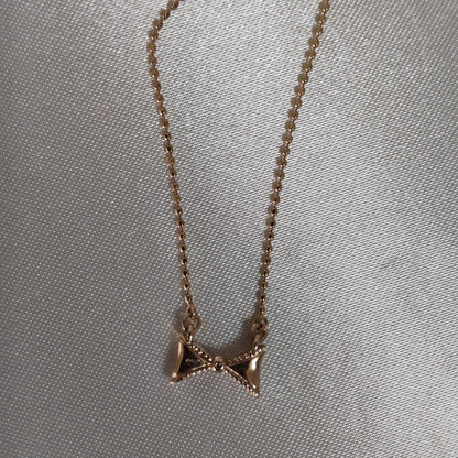 Beautiful agete ribbon-shaped necklace made of pink gold displayed on a white background